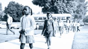 Elementary school aged black young girls in front of school bus in early 1970s during desgregation in Los Angeles California.